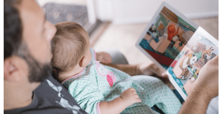 A dad reading to his infant. Vaccine safety matters. | Jennifer Margulis