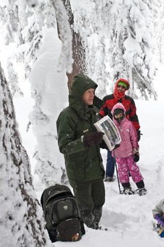 Ranger Dave Grimes holds up a photograph of lichen on a hemlock tree. It is worth driving a long distance to snowshoe at Crater Lake in Southern Oregon. Photo by Jennifer Margulis