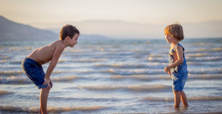 10 tips for traveling solo with kids. Photo of two children at the beach, courtesy of Limor Zellermayer, via Unsplash. | Jennifer Margulis