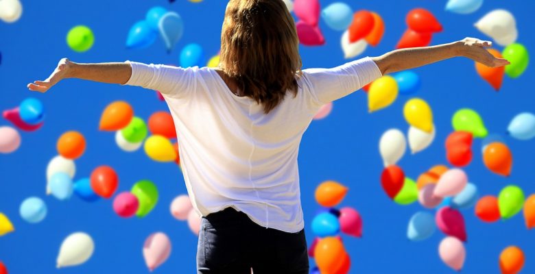 Say yes to happiness but what do you say to blog giveaways? Yay or nay? Photo of a woman glorying in balloons via Pixabay. | Jennifer Margulis