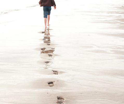 A young girl walking along the beach in the Taft District of Lincoln City, Oregon.