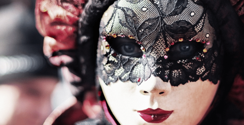 Writers experience imposter syndrome. A photo of a masked person at a carnival. Via Jennifer Margulis, Ph.D.