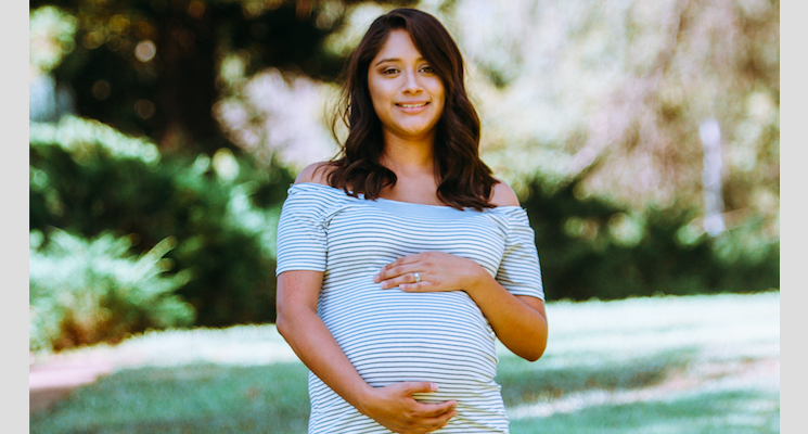 Photo of pregnant woman in a striped dress by Omar Lopez on Unsplash